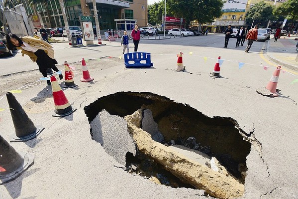 路面突然塌陷驚現一米深大坑　路人駐足圍觀(圖)